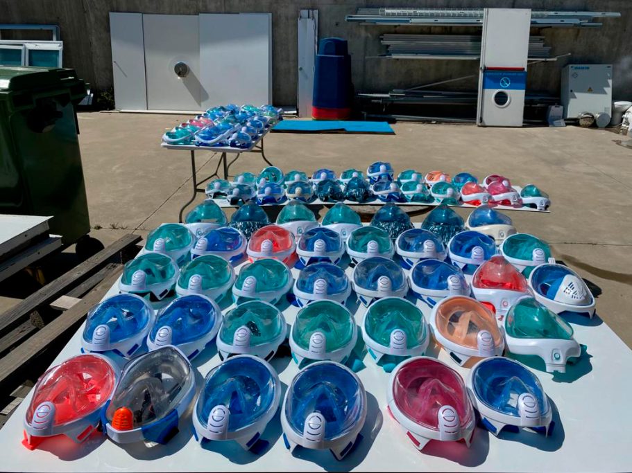 Mascarillas de buceo preparadas para su limpieza dispuestas sobre una mesa.