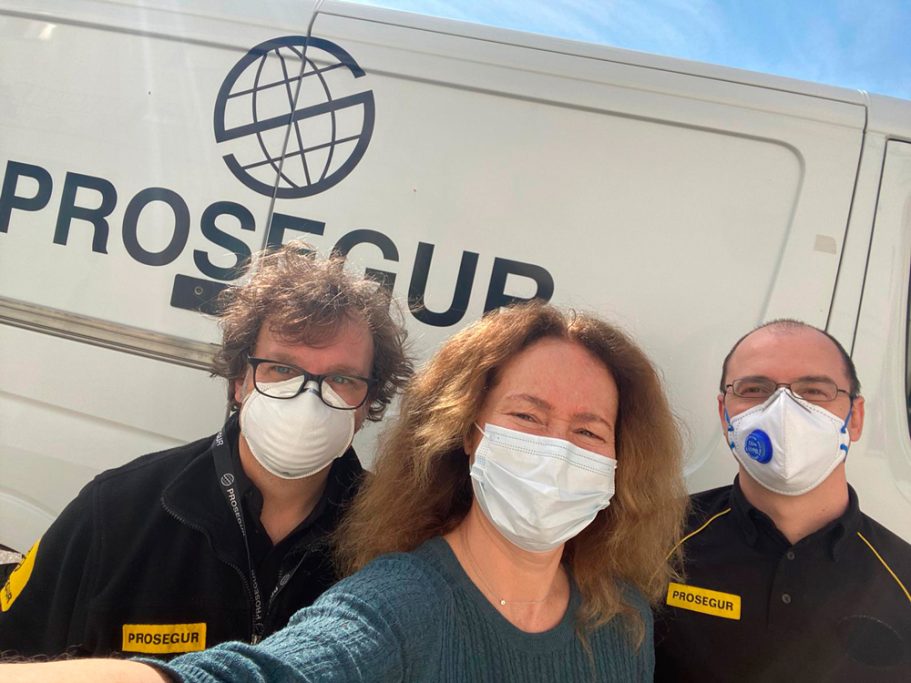 Tres personas con mascarillas posan frente a una furgoneta de Prosegur.