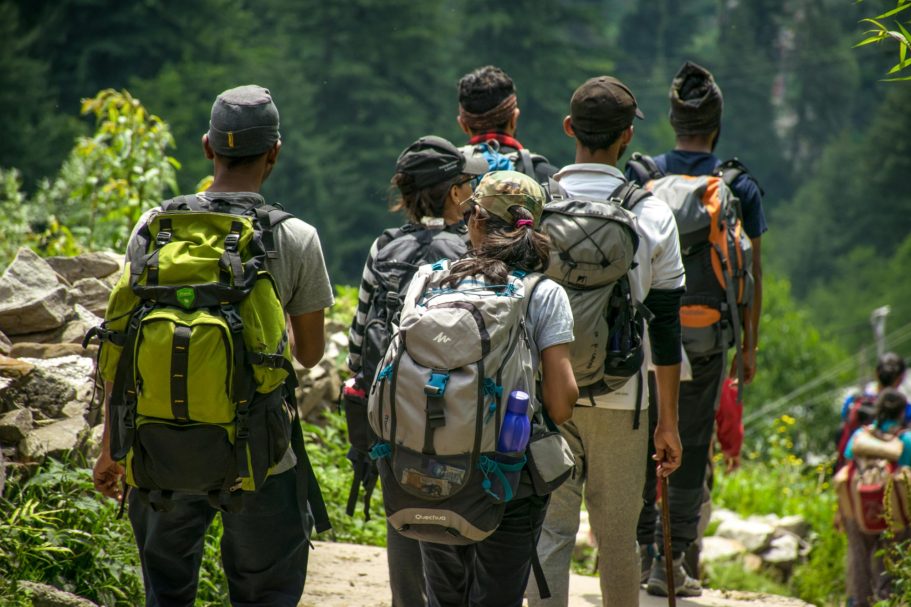 Grupo de jóvenes caminando por un sendero en un entorno montañoso.