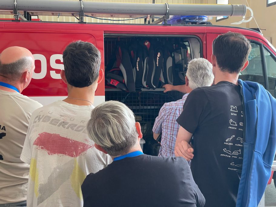 Grupo de personas observando el interior de un vehículo de bomberos.