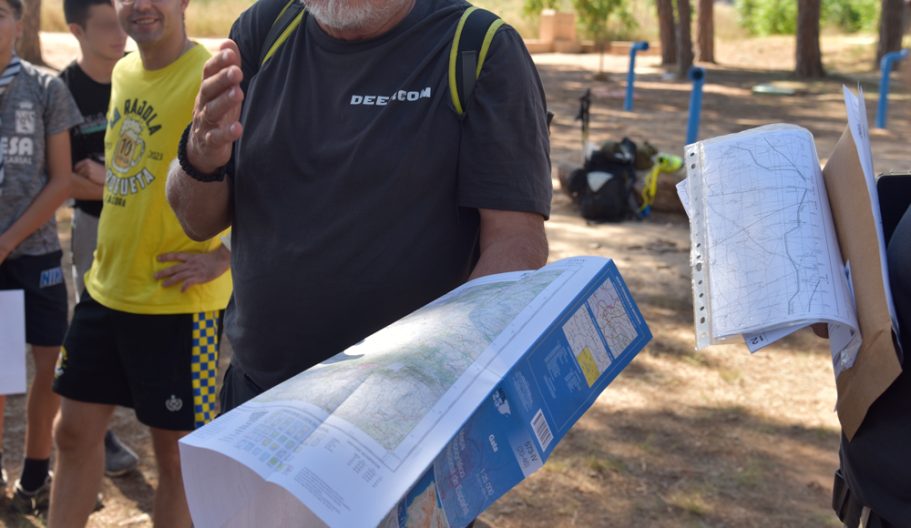 Formación sobre orientación, Instructor sosteniendo un mapa en un entorno al aire libre.