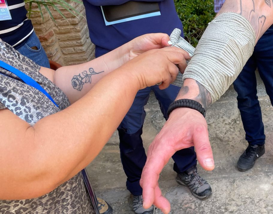 Mujer colocando vendaje israelí sobre brazo.
