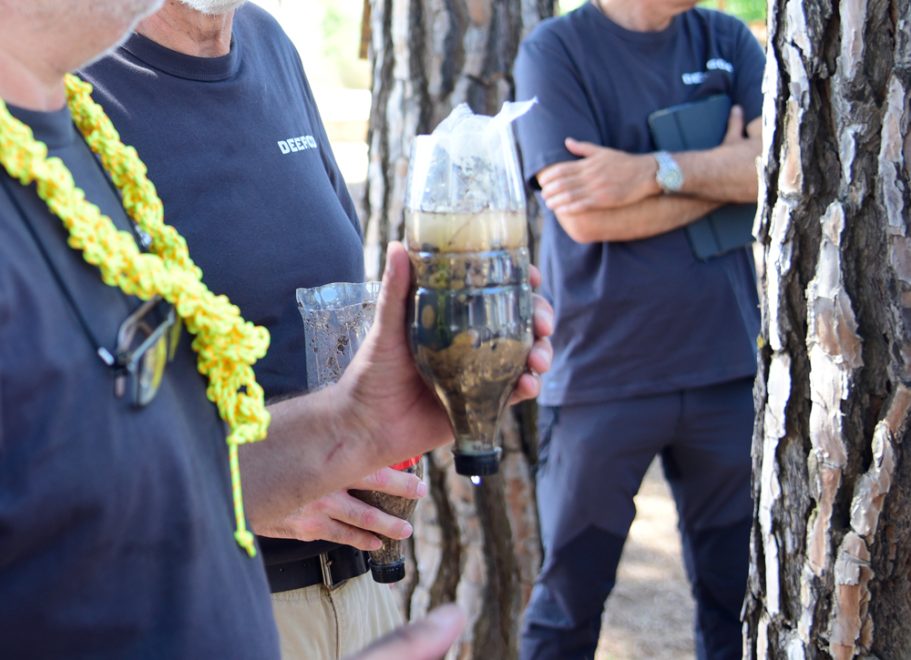 Enseñando sobre filtrados de agua frente a un grupo de personas.