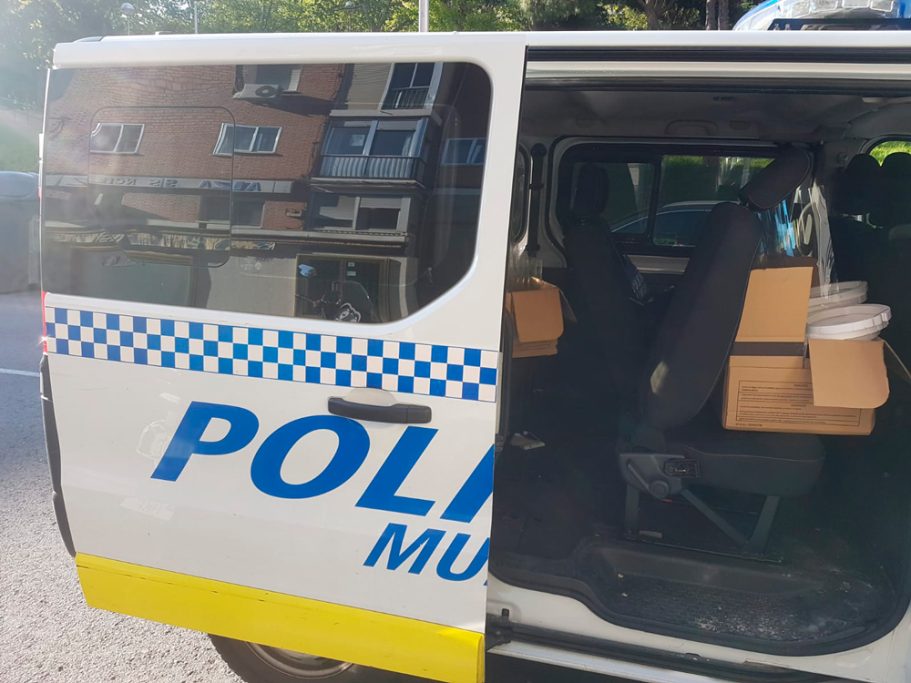 Furgoneta de Policial Municipal con cajas de material para reparto.